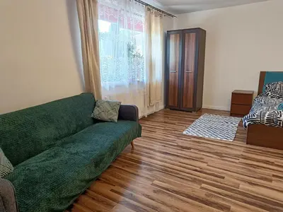 a living room with a green couch and a wooden floor at Dom pod Krakowem - zacisze wsi 20 minut samochodem od centrum Krakowa in Pekowice