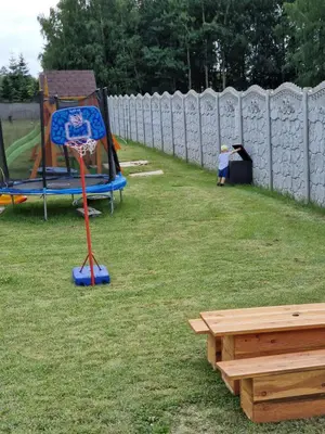 a backyard with a basketball hoop in the grass at Energylandia Apartamenty u Agi D in Zator