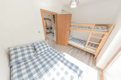 a bedroom with a bed and a bunk bed with a tub at Energylandia Apartamenty u Agi D in Zator