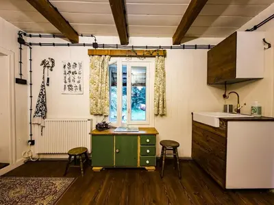 a kitchen with a green cabinet and a window at Grapa - Magiczna Leśna Chata in Skawica