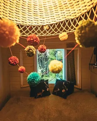 a room with pom poms hanging from a ceiling at Grapa - Magiczna Leśna Chata in Skawica