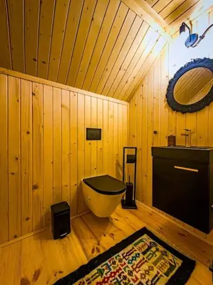 a bathroom with a tub in a wooden room at Grapa - Magiczna Leśna Chata in Skawica