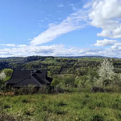 a house in the middle of a field at Pod lasem i niebem in Lanckorona