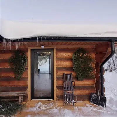 a log cabin with snow on the roof at Pod lasem i niebem in Lanckorona