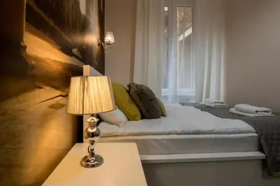 a bedroom with a bed with a lamp and a window at One Bedroom Apartment - Dluga 30 street in Kraków