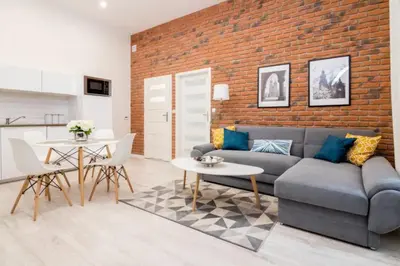 a living room with a couch and a brick wall at One Bedroom Apartment - Dluga 30 street in Kraków