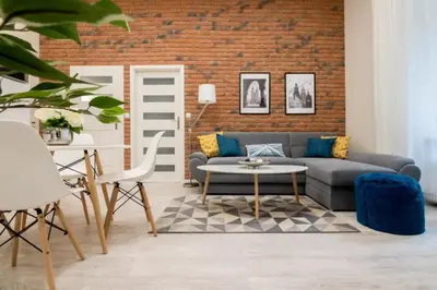a living room with a couch and a brick wall at One Bedroom Apartment - Dluga 30 street in Kraków