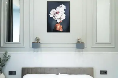 a bedroom with a bed and a picture of a flower at Vintage Charm in Old Town Krakow Józefa Sarego apt A in Kraków