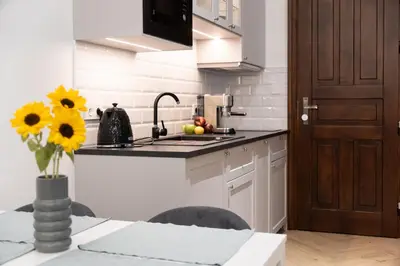 a kitchen with a table with a vase of flowers at Vintage Charm in Old Town Krakow Józefa Sarego apt A in Kraków