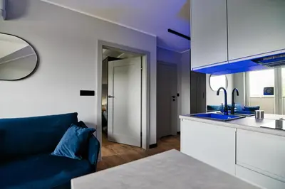 a living room with a blue couch and a kitchen at Jasmine by Housine in Zator