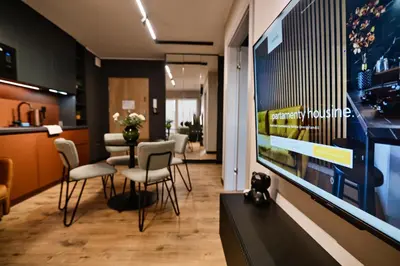 a living room with a tv and a table with chairs at Jasmine by Housine in Zator