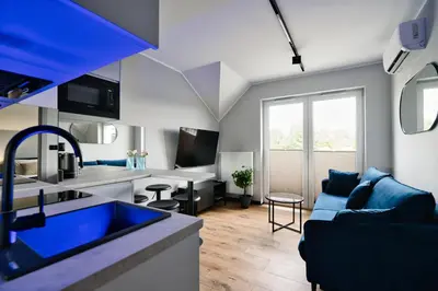 a kitchen and living room with a blue couch at Jasmine by Housine in Zator