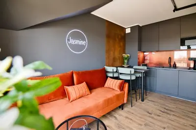 a living room with an orange couch and a kitchen at Jasmine by Housine in Zator