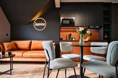 a living room with a couch and a table with chairs at Jasmine by Housine in Zator