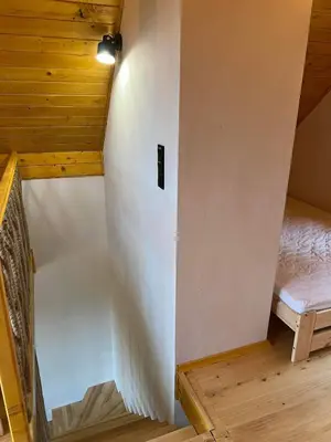 a room with a white wall next to a bed at Chatki u Atki - Zawada Lanckorońska in Zakliczyn