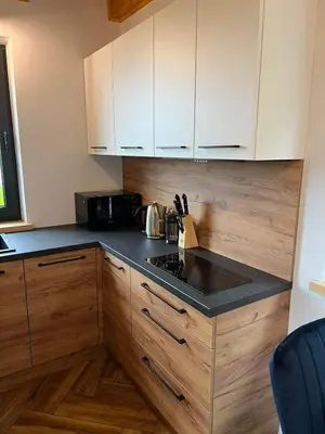 a kitchen with white cabinets and a stove top oven at Chatki u Atki - Zawada Lanckorońska in Zakliczyn