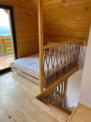 a staircase in a wooden room with a bed at Chatki u Atki - Zawada Lanckorońska in Zakliczyn