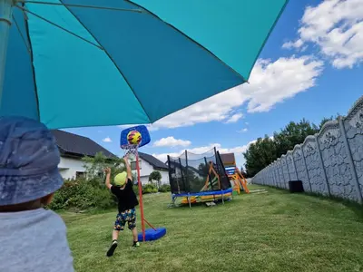 a person holding an umbrella next to a playground at Energylandia Domki-Apartamenty u Agi G in Zator