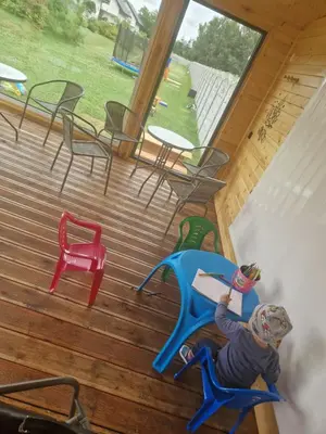 a young child playing on a playground on a deck at Energylandia Domki-Apartamenty u Agi G in Zator