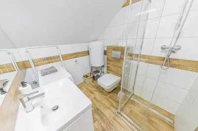 a bathroom with a sink and a toilet at Energylandia Domki-Apartamenty u Agi G in Zator