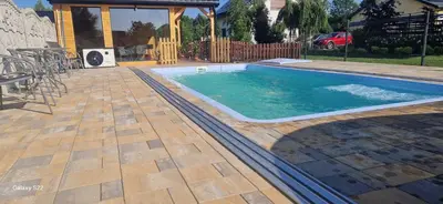 a swimming pool in a backyard with a table and chairs at Energylandia Domki-Apartamenty u Agi G in Zator