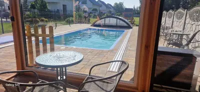 a patio with a table and chairs and a swimming pool at Energylandia Domki-Apartamenty u Agi G in Zator