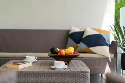 a table with a bowl of fruit and cups on a couch at Stare Miasto z widokiem na ogród, bezpłatny parking, szybkie Wi-Fi in Kraków