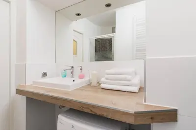 a white bathroom with a sink and a mirror at Private Parking - Old Town - Św Krzyża 16 Street in Kraków