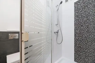 a bathroom with a shower with a glass door at Private Parking - Old Town - Św Krzyża 16 Street in Kraków