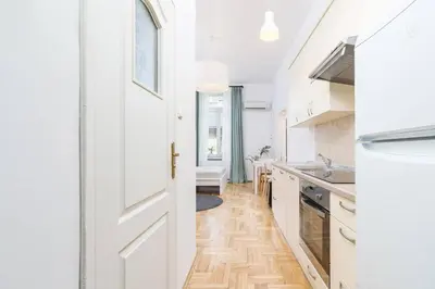 a kitchen with white cabinets and a white door at Private Parking - Old Town - Św Krzyża 16 Street in Kraków