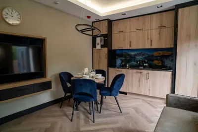 a dining room with a table and chairs and a tv at Władysławka in Rabka-Zdroj