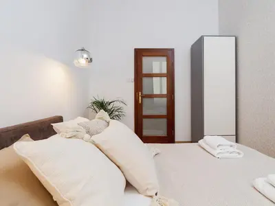 a bedroom with a bed with white pillows at Main Square Apartment - Private Parking - Św Krzyża 16 in Kraków