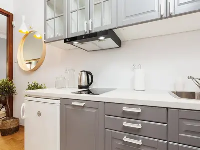 a kitchen with white and gray cabinets and a sink at Main Square Apartment - Private Parking - Św Krzyża 16 in Kraków