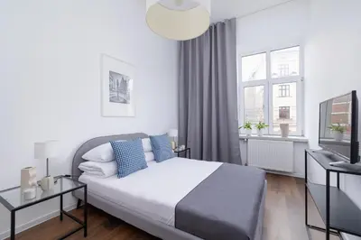 a white bedroom with a bed and a window at 2-Bedroom Apartment With Balcony - Długa 65 street in Kraków
