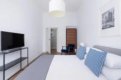 a white bedroom with a bed and a tv at 2-Bedroom Apartment With Balcony - Długa 65 street in Kraków