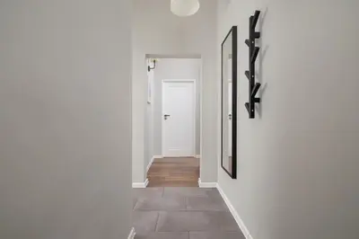 a hallway with white walls and a white door at 2-Bedroom Apartment With Balcony - Długa 65 street in Kraków