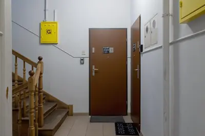a hallway with a brown door in a building at 2-Bedroom Apartment With Balcony - Długa 65 street in Kraków
