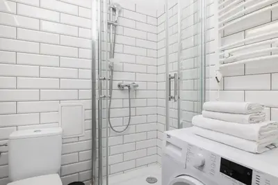 a white bathroom with a shower and a toilet at 2-Bedroom Apartment With Balcony - Długa 65 street in Kraków