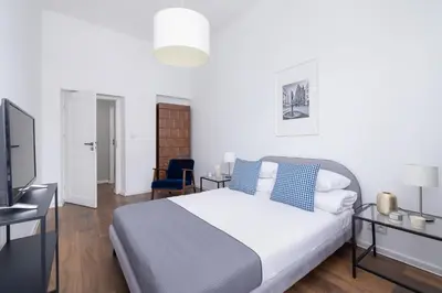 a bedroom with a large bed and a television at 2-Bedroom Apartment With Balcony - Długa 65 street in Kraków