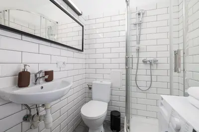 a white bathroom with a toilet and a sink at 2-Bedroom Apartment With Balcony - Długa 65 street in Kraków