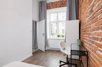 a room with a brick wall and a table and a chair at 2-Bedroom Apartment - Długa 65 Street in Kraków