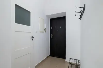 a black door in a white room with a television at 2-Bedroom Apartment - Długa 65 Street in Kraków