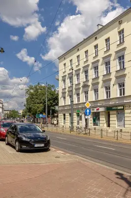 a black car parked in front of a building at 2-Bedroom Apartment - Długa 65 Street in Kraków