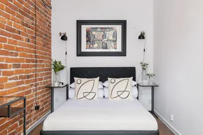 a bed in a room with a brick wall at 2-Bedroom Apartment - Długa 65 Street in Kraków