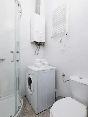 a white bathroom with a washing machine and a toilet at 1-bedroom apartment - Długa 65 street in Kraków