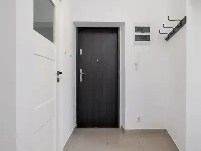 a hallway with a black door in a white room at 1-bedroom apartment - Długa 65 street in Kraków