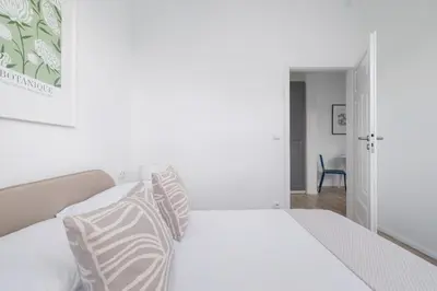 a bedroom with a white bed with striped pillows at 2 Bedroom Apartment - Długa 65 in Kraków