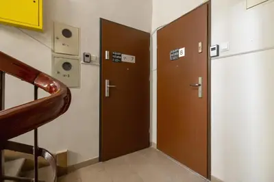 two brown doors in a room with a staircase at 2 Bedroom Apartment - Długa 65 in Kraków