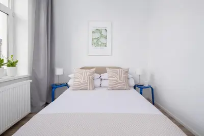 a white bedroom with a white bed with pillows at 2 Bedroom Apartment - Długa 65 in Kraków