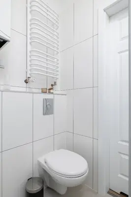 a white bathroom with a toilet and a window at 2 Bedroom Apartment - Długa 65 in Kraków
